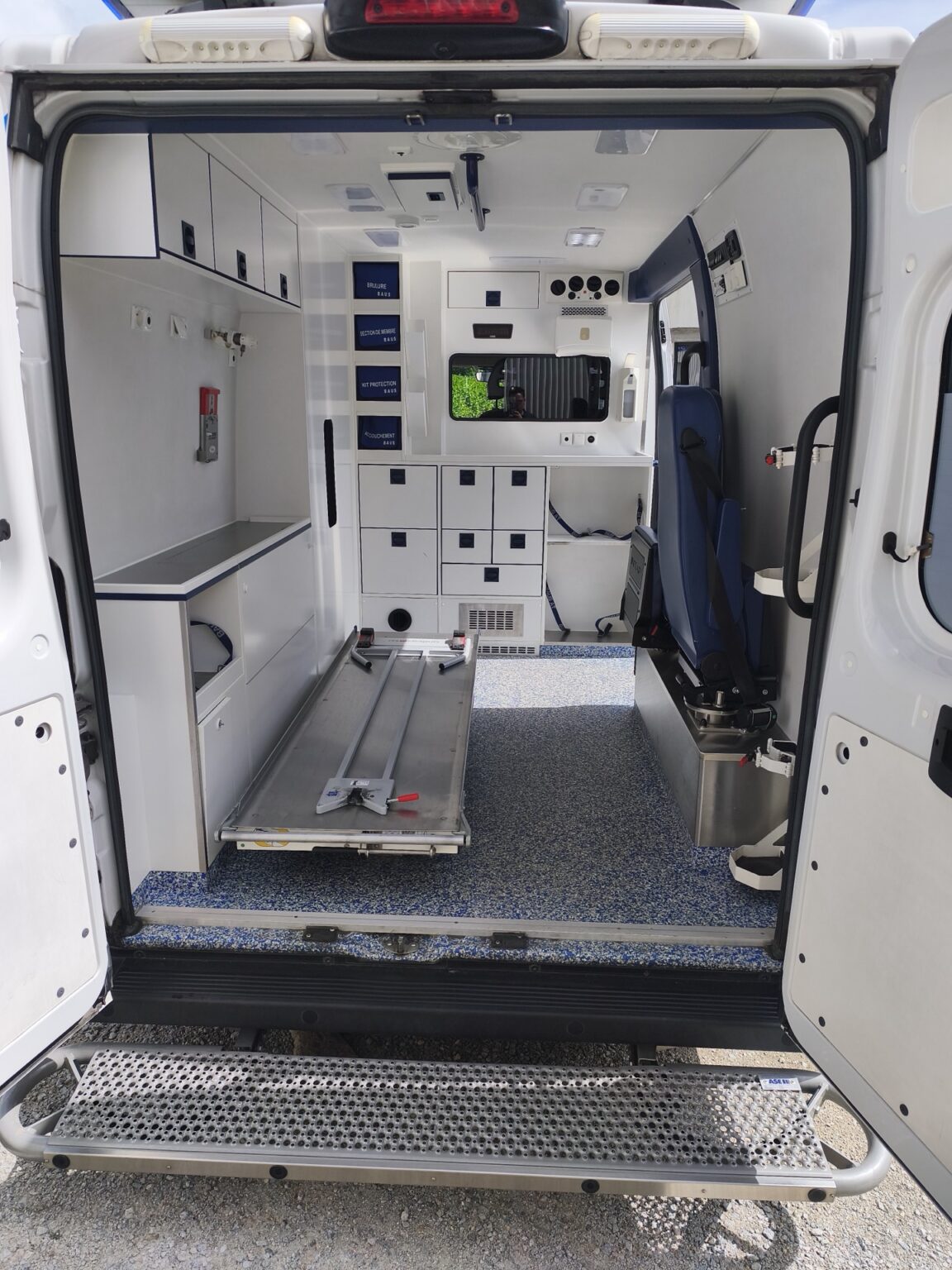 Cellule sanitaire de l'ambulance ASSU vue de l'arrière, avec support de brancard