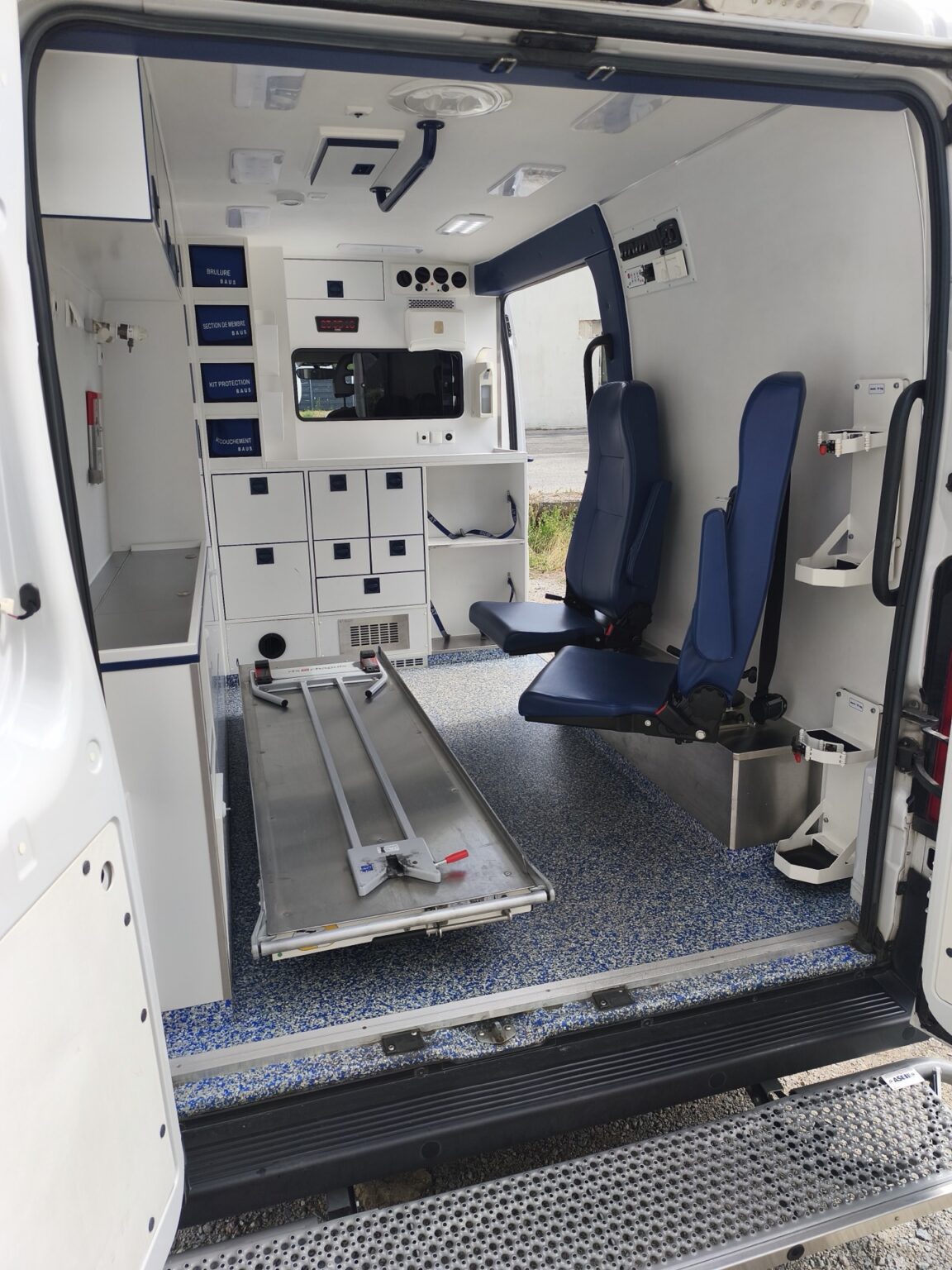 Intérieur de l'ambulance ASSU avec sièges accompagnants et rangements médicaux